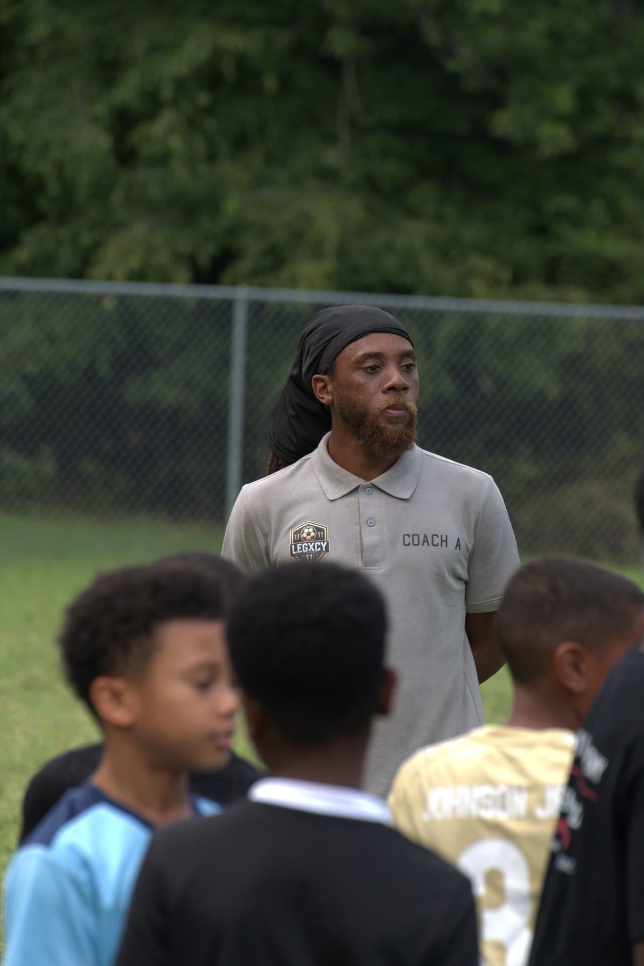 Coach A speaking to Legacy players gathered around him during a session